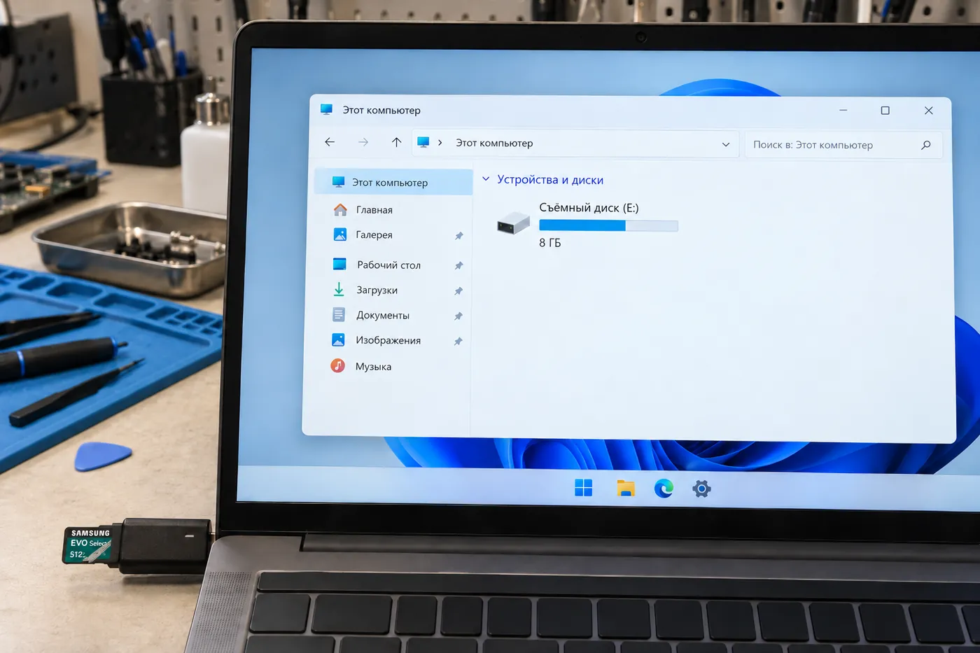Ноутбук на столе мастера: в Проводнике Windows съёмный диск E: объёмом 8 ГБ, в USB-картридер сбоку вставлена карта Samsung EVO Select на 512 ГБ.